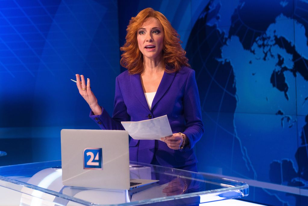 News anchorwoman with red hair in blue costume, holding a stack of paper gesticulating with her hand. Julian Rosefeldt, Sammlung Goetz Munich 