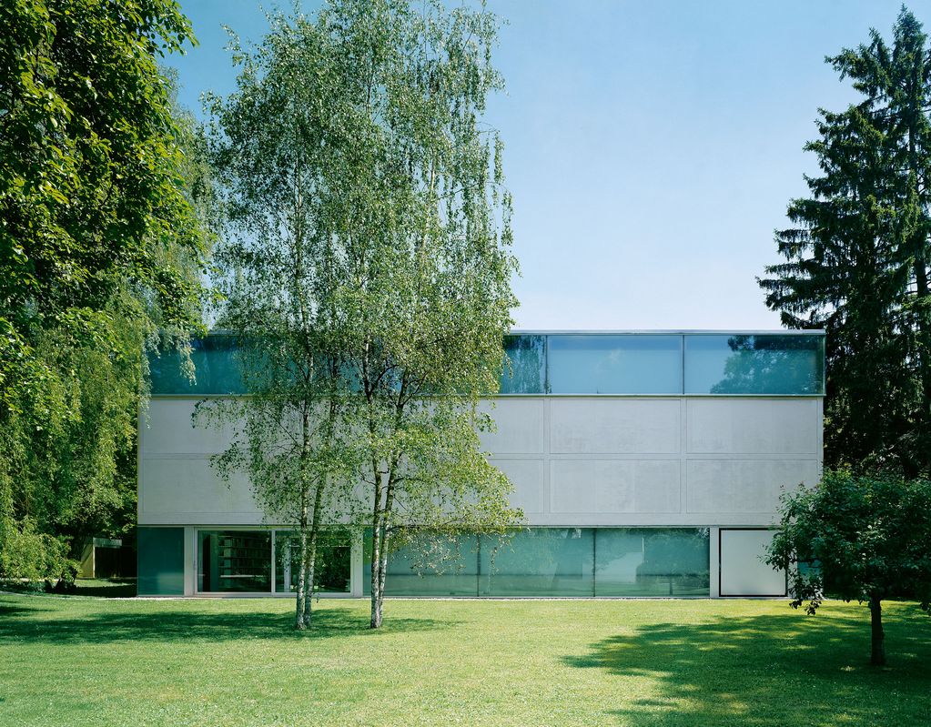 The exhibition building of the Sammlung Goetz seen from the garden. Four tall birch trees stand in front of the building