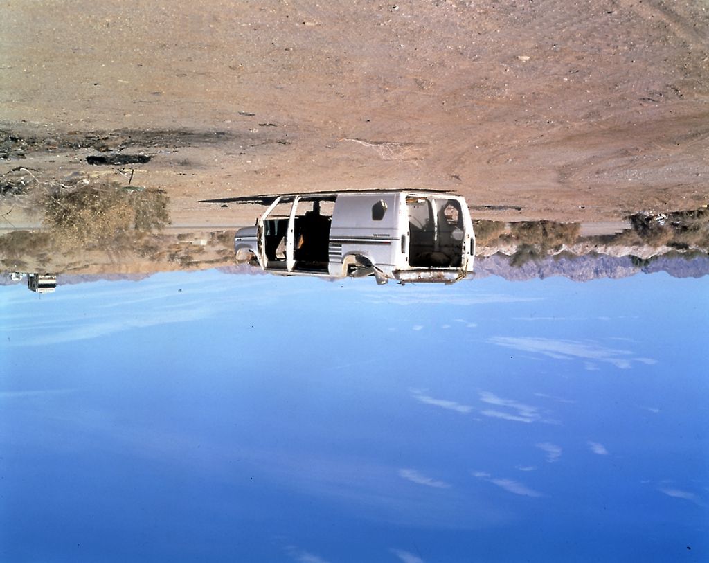 Reversed color photograph of a white van in the desert with a bright blue sky. Sammlung Goetz, Munich
