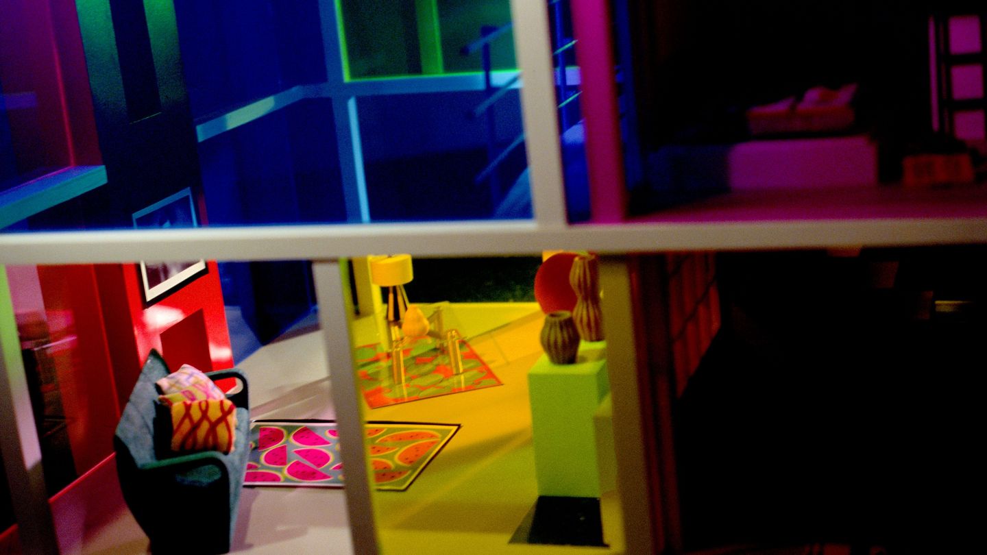 Photograph of a view from the outside into the colourfully designed interior of a miniature house. Laurie Simmons, Sammlung Goetz Munich