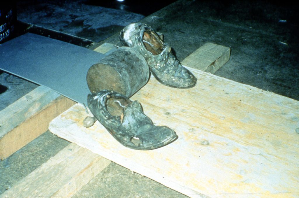 The almost overexposed video Still shows a worn pair of men's shoes on a wooden board. Fischli/Weiss, Sammlung Goetz Munich