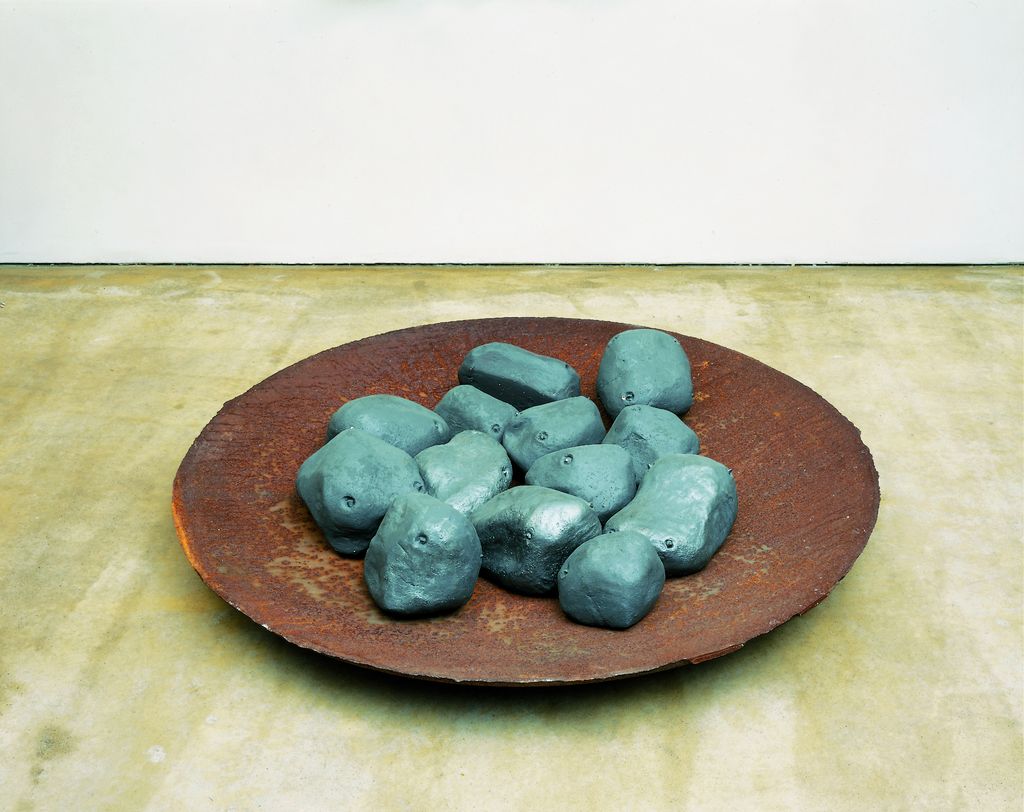 Diese Aufnahme zeigt anthrazitfarbene Kartoffeln aus Ton in Gusseisenschale.