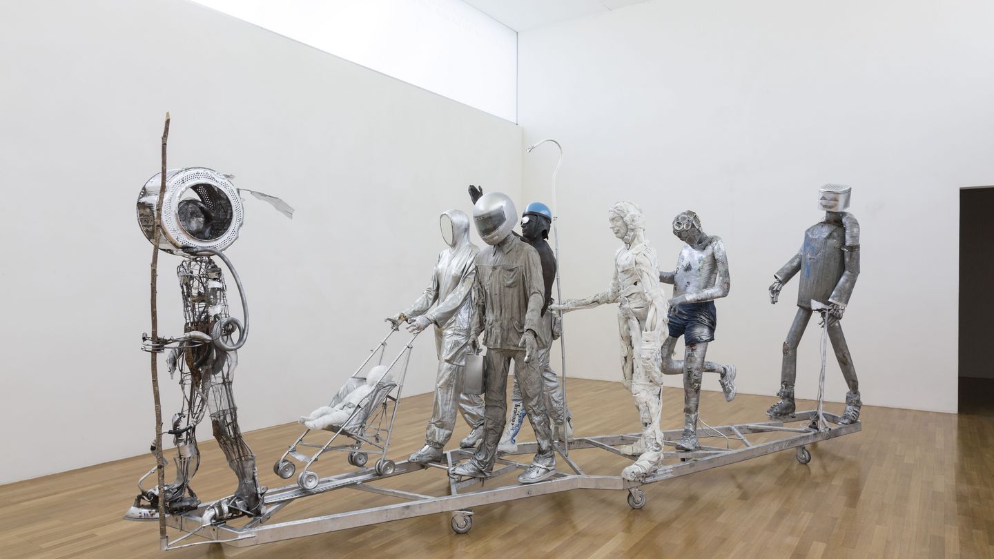 Installation view of the work "Bródno People" in the Goetz Collection. The work consists of several figures in silver or white that more or less resemble the human form and form a procession. Paweł Althamer, Sammlung Goetz Munich