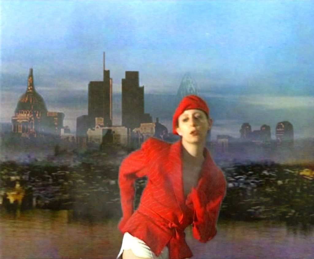 Video Still with a person dressed in red in the foreground who seems to be making a dance movement. In the background is the silhouette of the skyline of a city, possibly London. Mark Leckey, Sammlung Goetz Munich