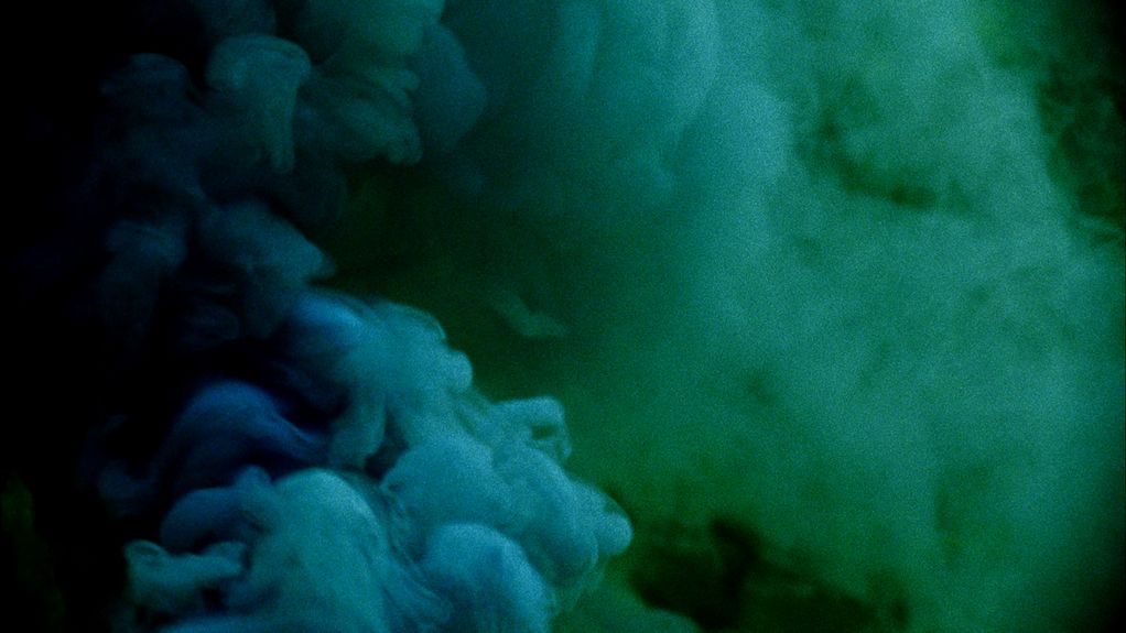 Auf diesem Filmstill sieht man Rauchwolken in den Farbtönen dunkelblau bis türkis. Cyrill Lachauer, Sammlung Goetz München