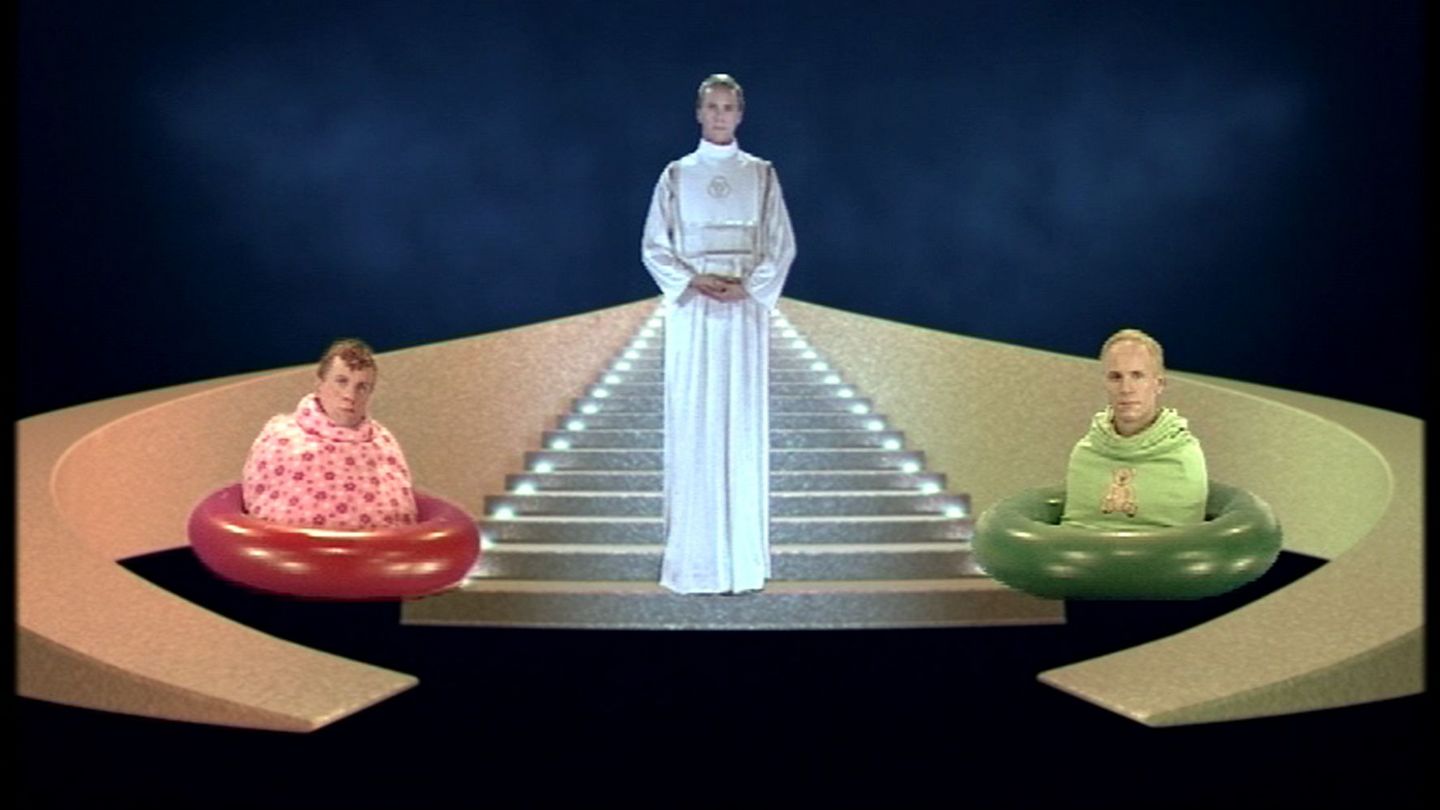 Outdated science ftiction szenario with a white dressed figure in the middle on a staircase, left and right two half-figures in a rubber ring 