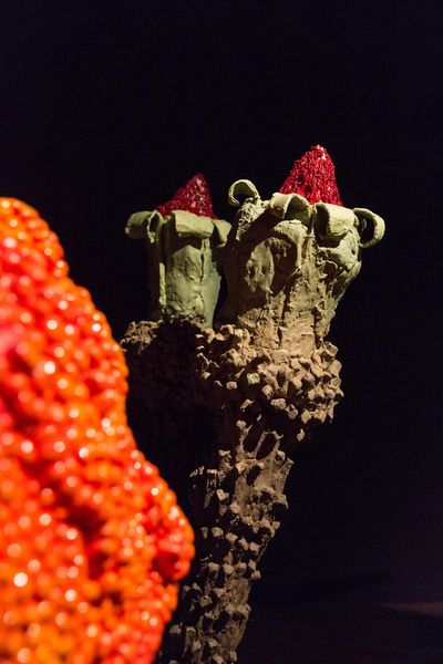 Detail aus der Installation von "The Experiment". Zu sehen ist eine exotische Blume oder Knospe aus aufbauendem künstlerischem Material, deren zwei Spitzen rot leuchten. Nathalie Djurberg, Sammlung Goetz München