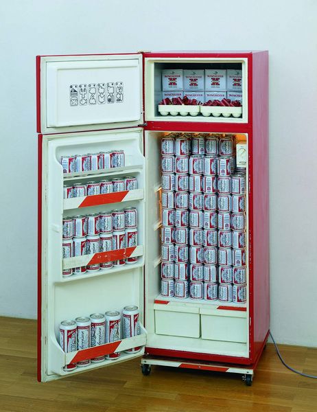 Hier ist ein Objekt des Künstlers Tom Sachs abgebildet, welches aus einem Kühlschrank gefüllt mit Budweiser Bierdosen, Schrotpatronen und Patronenschachteln besteht.