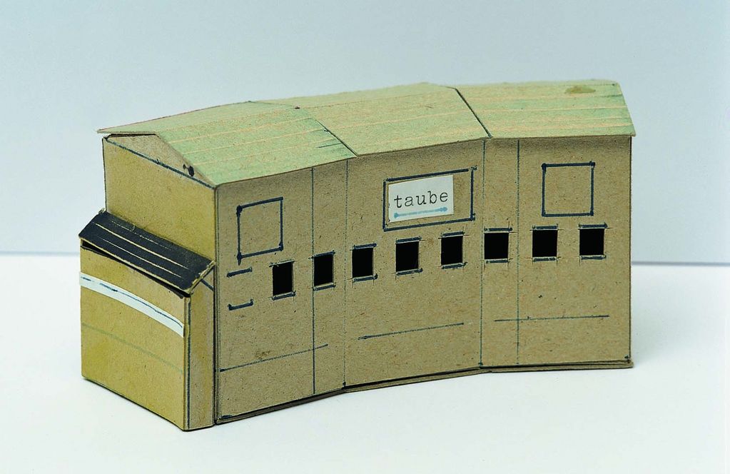 Auf dieser Fotografie ist das Modell eines Gebäudes mit der Aufschrift: "Taube" zu sehen.