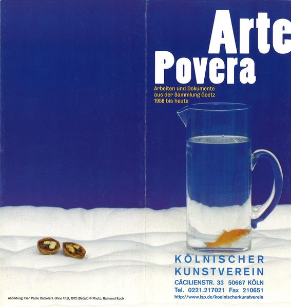 Diese Einladungskarte zeigt einen Ausschnitt einer Arbeit von Pier Paolo Calzolari. Im Hintergrund ist blaue Leinwand und im Vordergrund Teile der schneeweißen Matratze, zwei Walnusshälften und eine Karaffe mit Wasser samt Goldfisch darin zu sehen.