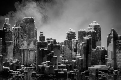 Auf dieser Schwarzweißaufnahme ist eine Modell-Skyline aus Zuckerwürfeln, von der weißer Nebel aufsteigt, zu sehen. Hans Op de Beeck, Sammlung Goetz München