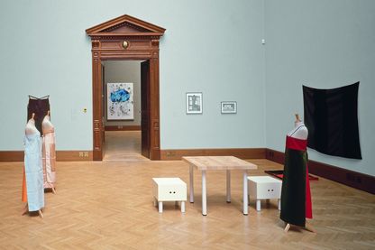 Hier ist ein Ausstellungsraum mit Textilarbeiten, Möbeln und Skizzen von Andrea Zittel zu sehen.