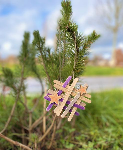 Anhänger aus Holzstäbchen an einem Nadelbaum