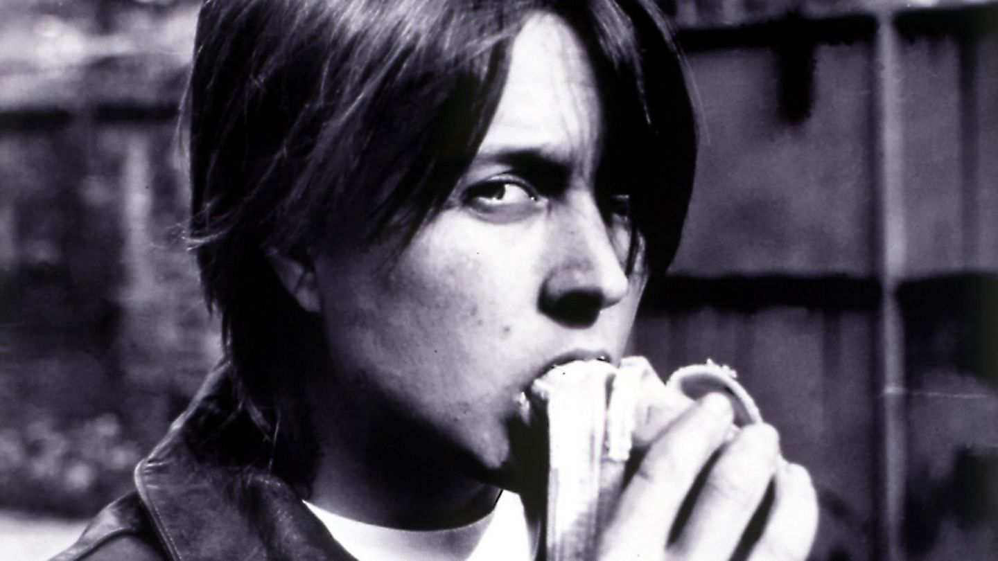 This black and white photograph is a self-portrait of the artist, in which she bites into a half peeled banana and looks into the camera.