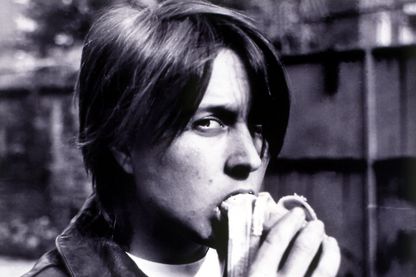 This black and white photograph is a self-portrait of the artist, in which she bites into a half peeled banana and looks into the camera.