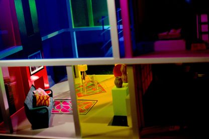 Fotografie einer Ansicht von außen in das bunt gestaltete Innere eines Miniaturhauses. Laurie Simmons, Sammlung Goetz München