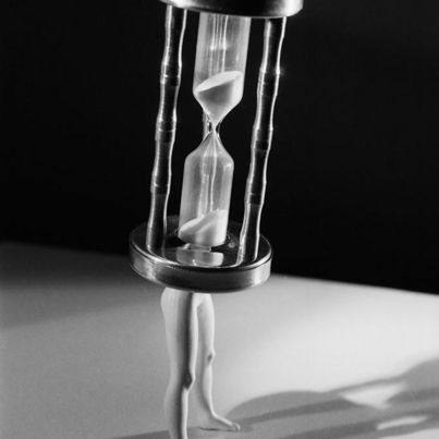 © Laurie Simmons Black and white photograph of hourglass with doll legs