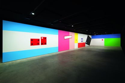 Ausstellungsansicht mit bunt und minimalistisch gestalteten, eingezogenen Wänden in einem schwarz gestrichenen Ausstellungsraum. Gerwald Rockenschaub, Sammlung Goetz München