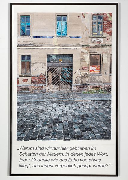 Painting of a run-down house facade, in front of it is a paved street. The facade is smeared with graffiti, including a Star of David on the entrance gate. Under the painting is written: "Warum sind wir nur hier geblieben im Schatten der Mauern, in denen jedes Wort, jeder Gedanke wie das Echo von etwas klingt, das längst vergeblich gesagt wurde?" (Why did we only stay here in the shadow of the walls, where every word, every thought sounds like the echo of something that was said long ago in vain?)