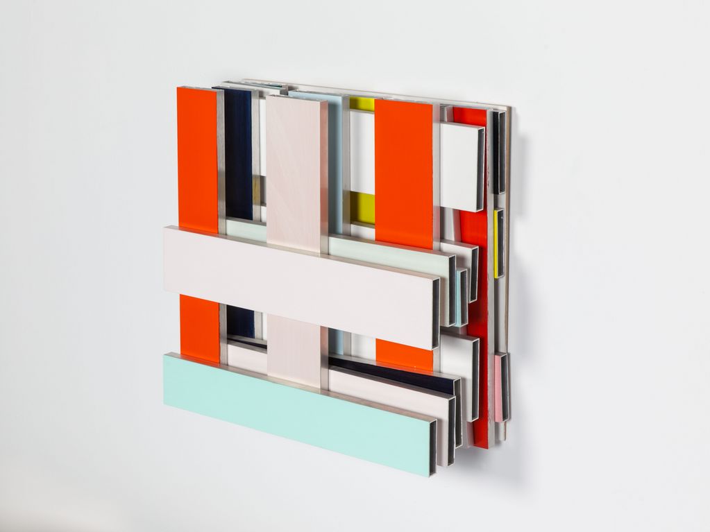 Wall object made of rectangular metal bars cut to size and painted in different colors, forming a kind of square grid. 