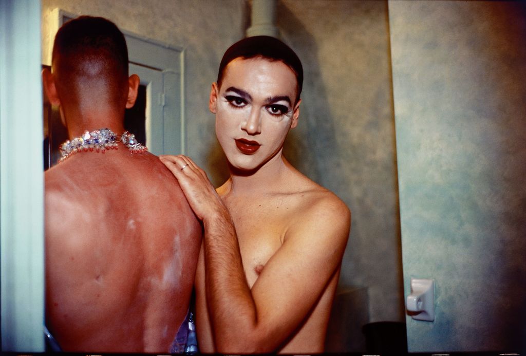 Hierbei handelt es sich um ein intimes Porträt zweier Drag Queens, die eine mit dem Rücken zu dem Betrachtenden stehend, die andere in die Kamera blickend, während sie sich gerade für eine Show umzukleiden scheinen. Nan Goldin, Sammlung Goetz München