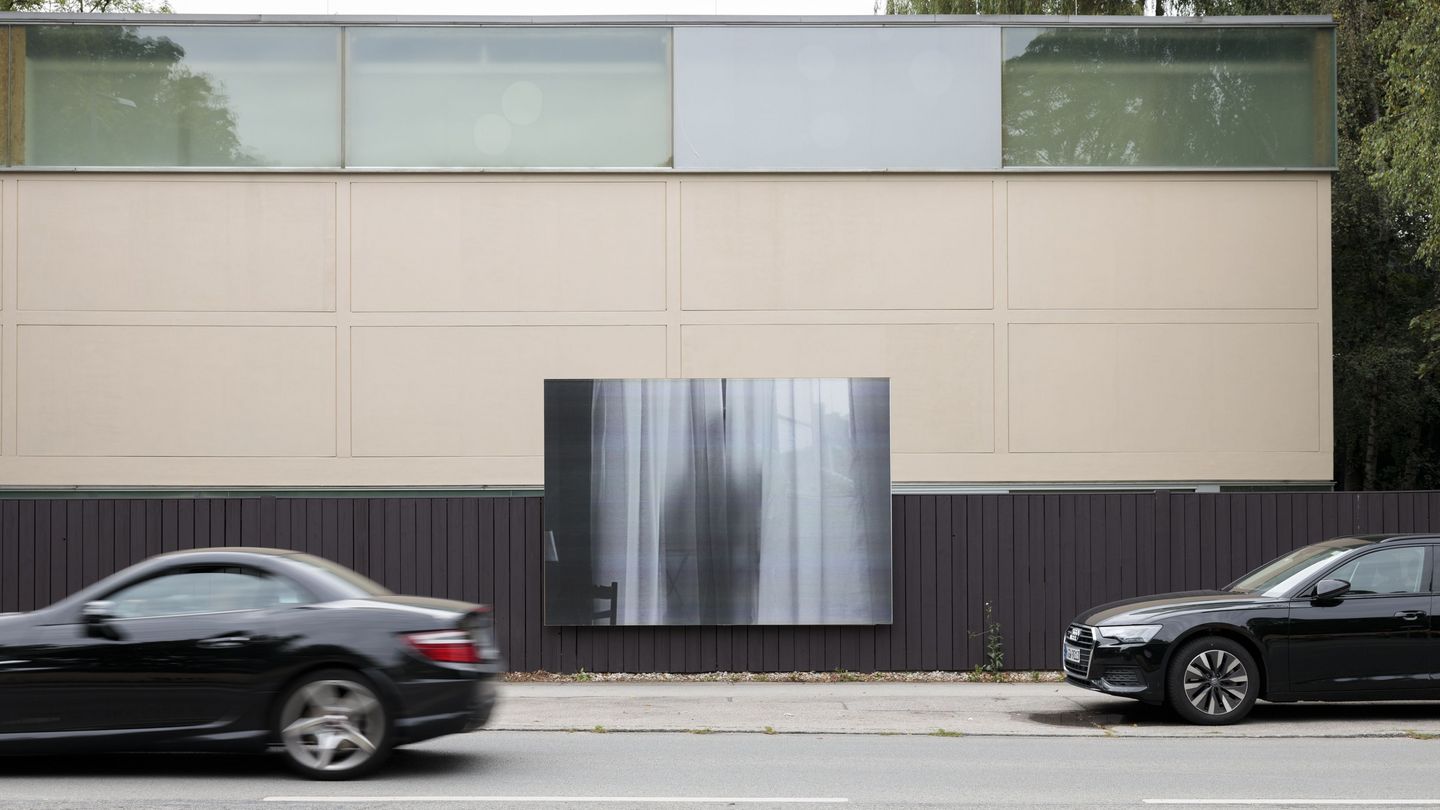 Plakatwand am Zaun vor der Sammlung Goetz Schwarzweißfotografie, der Schatten eines Menschen zeichnet sich hinter einem Vorhang ab, Felix Gonzalez-Torres, Sammlung Goetz, Muenchen