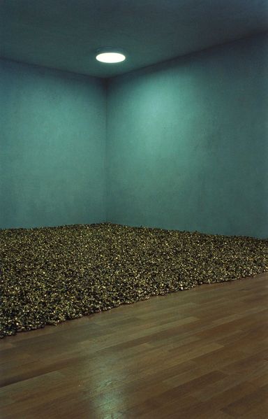 In this installation photograph, half of the floor is covered with candy wrapped in golden paper.