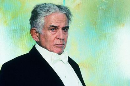 Diese Aufnahme zeigt ein Portrait des Harry Houdini-Charakters aus dem Cremaster-Zyklus des Künstlers Matthew Barney. Er trägt einen Smoking mit weißer Fliege und sieht im Dreiviertelprofil direkt in die Kamera. 