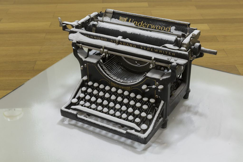 Das Detail der Arbeit zeigt eine alte schwarze Schreibmaschine mit weißem Pulver bestreut auf einer Spiegelplatte stehend, die ebenfalls mit dem weißen Pulver bestreut worden ist. Rodney Graham, Sammlung Goetz München