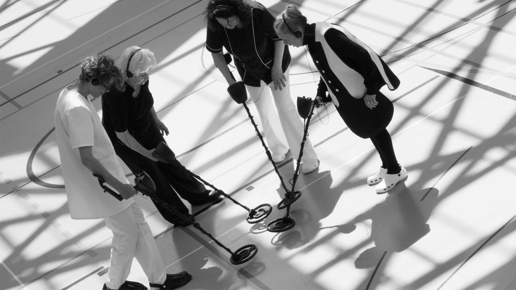 Schwarzweißfotografie von vier Frauen mit Metalldetektoren