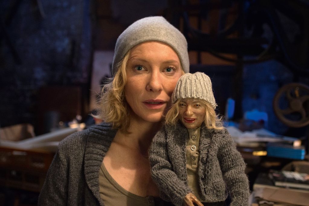Blonde Frau mit Mütze, die eine gleichaussehende Puppe hält. Julian Rosefeldt, Sammlung Goetz München